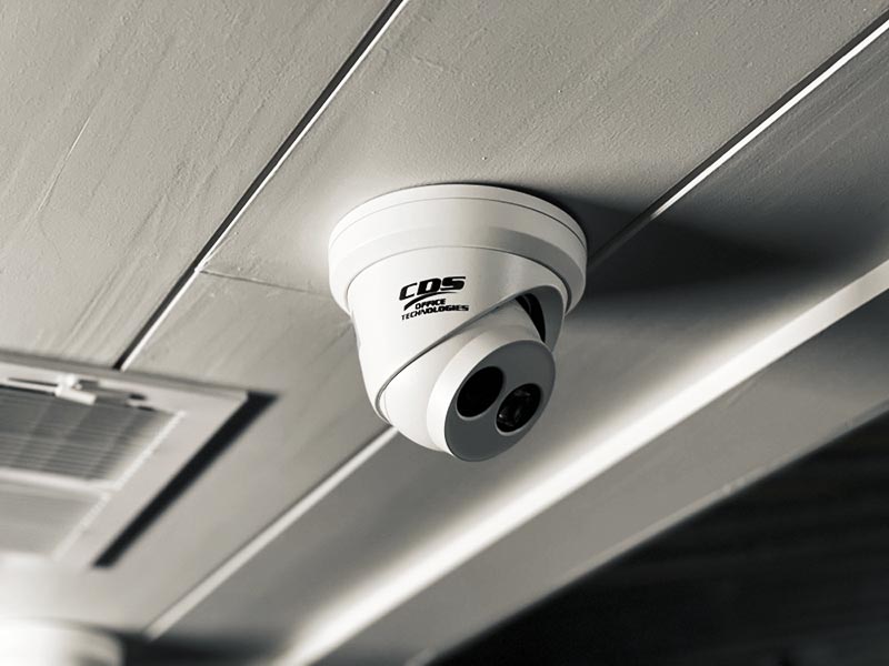 An installed surveillance camera covering a building entrance